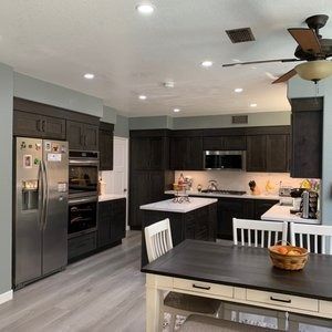 A kitchen with a table and chairs and a ceiling fan.
