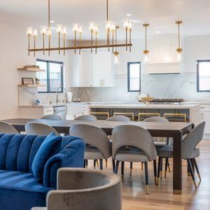 A living room with a blue couch , dining table and chairs.