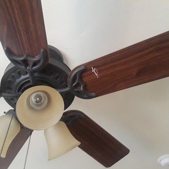 A close up of a ceiling fan with lights on it.