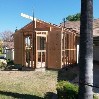 A wooden structure is being built in front of a house