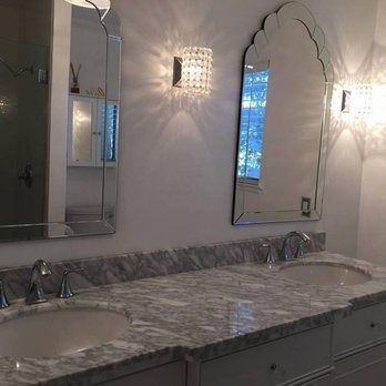 A bathroom with two sinks and two mirrors.