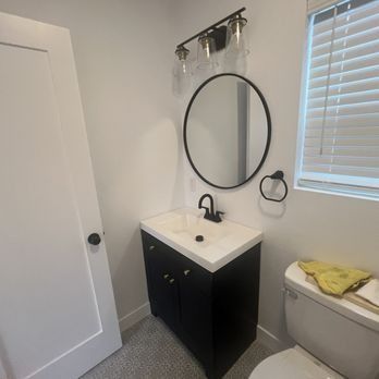 A bathroom with a sink , toilet and mirror.