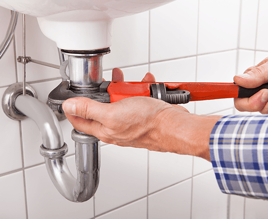 Male Plumber Fixing Sink — Wesley Chapel, FL — Tri-Care Services Inc