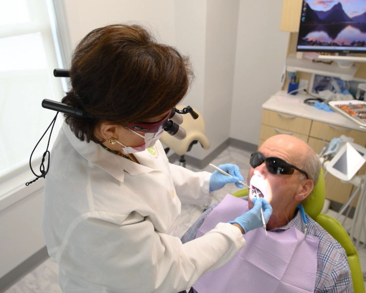 Group of smiling women in a healthcare office, some in scrubs, with flowers and diplomas.