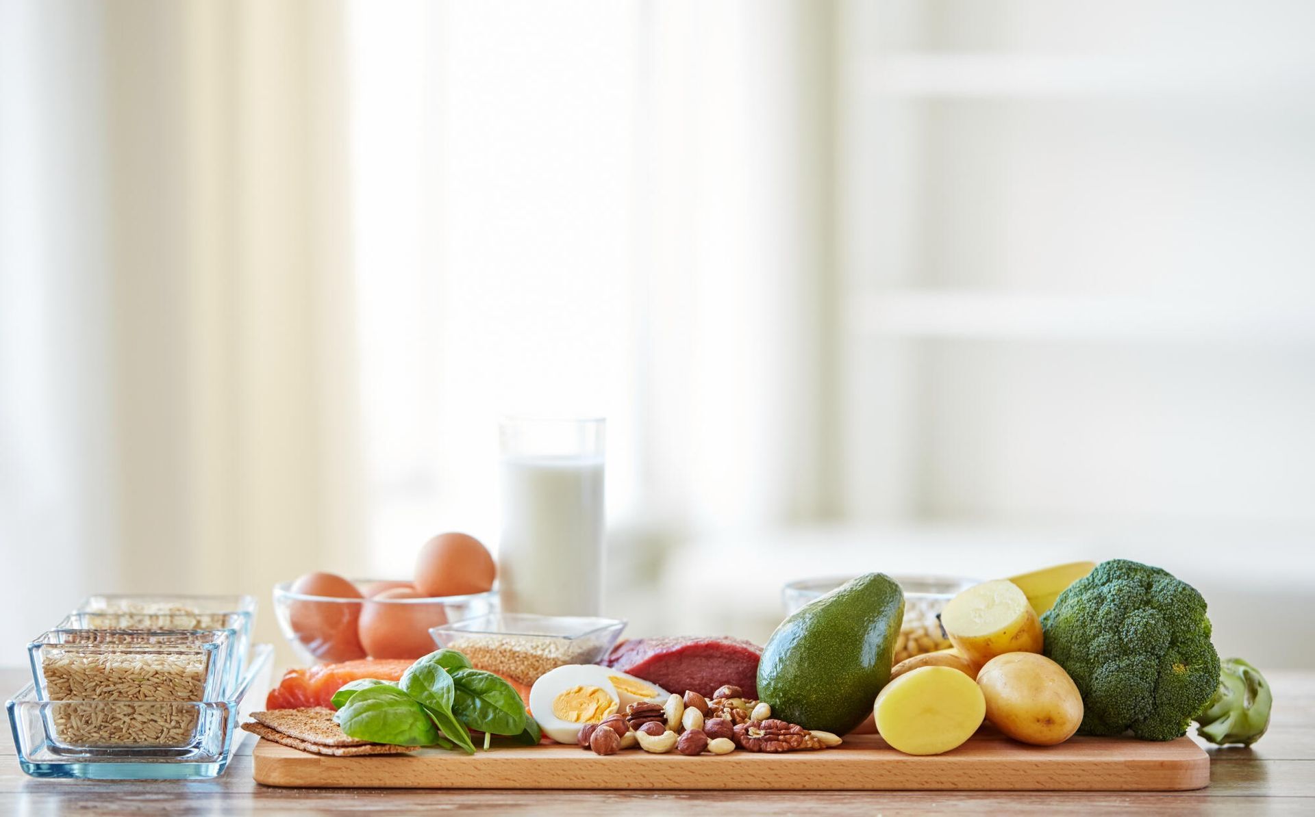 Assorted fresh fruits, vegetables, grains, and dairy arranged on a kitchen counter.