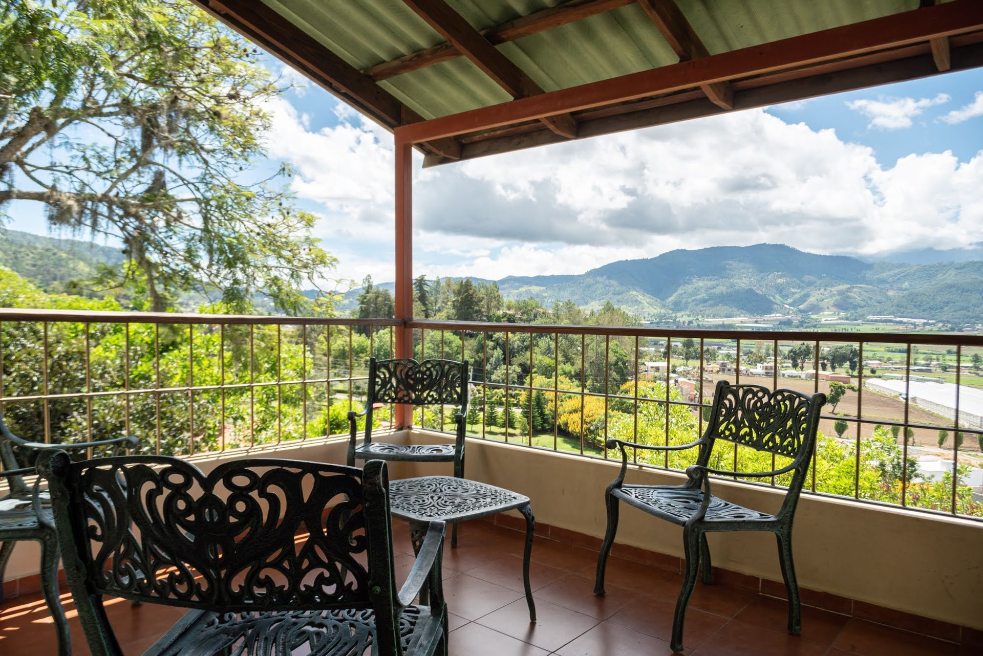 Un balcón con sillas y una mesa con vista a las montañas.