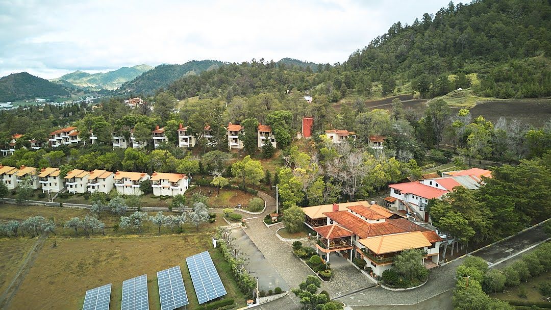 Una vista aérea de un pueblo con muchas casas y paneles solares.