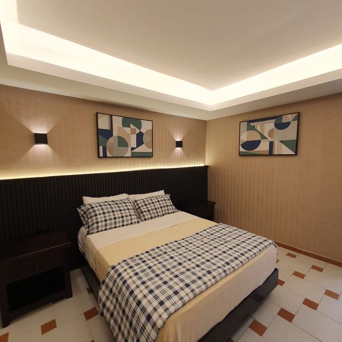 Un dormitorio con una cama y dos cuadros en la pared