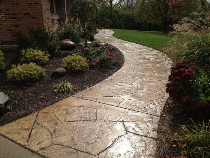 a picture of a stamped concrete sidewalk along a house that has flower beds on either side in Kent, OH.