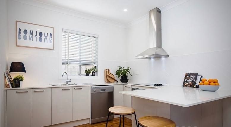 White kitchen with stainless steel range hood, dishwasher, and island — Lukas Joinery in Cessnock, NSW
