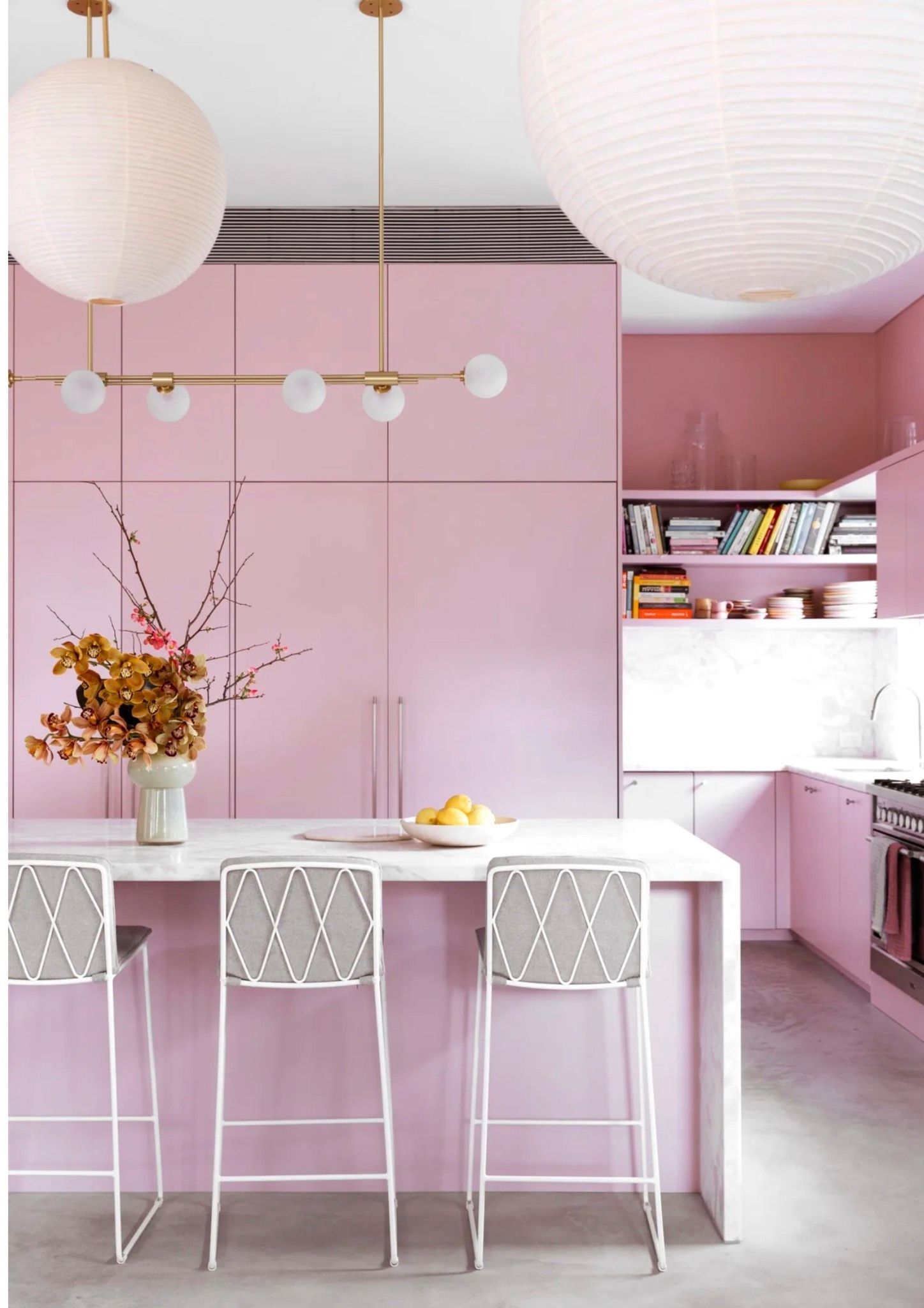 Pink kitchen with white countertops, stools, and globe pendant lights — Lukas Joinery in Newcastle, NSW