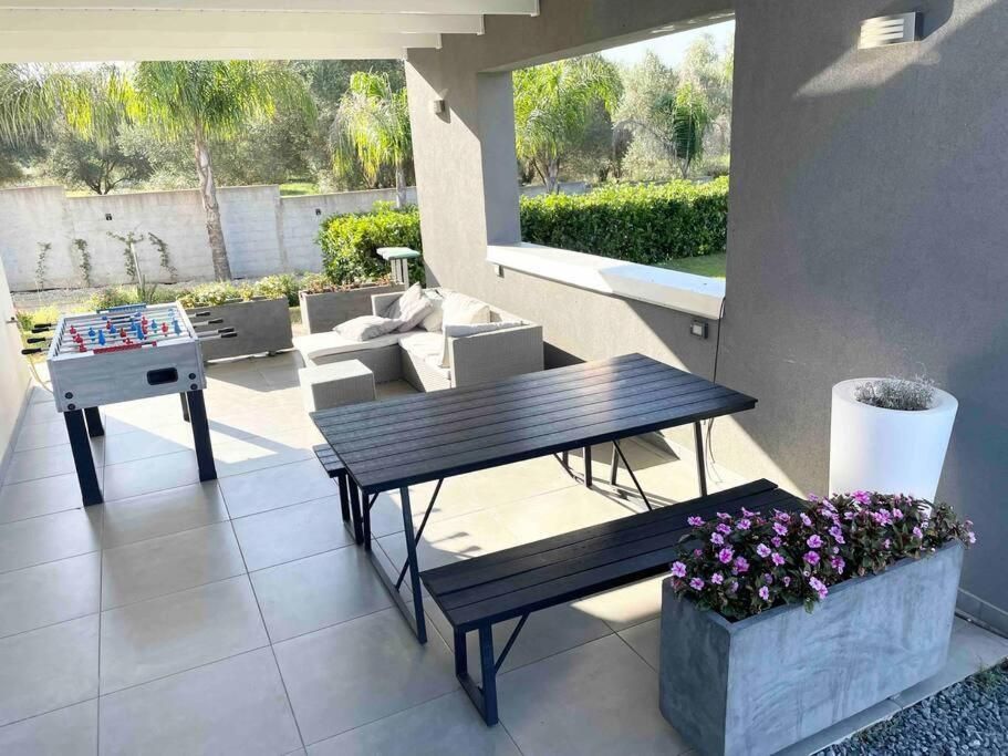 Un patio con tavolo, panche e biliardino.