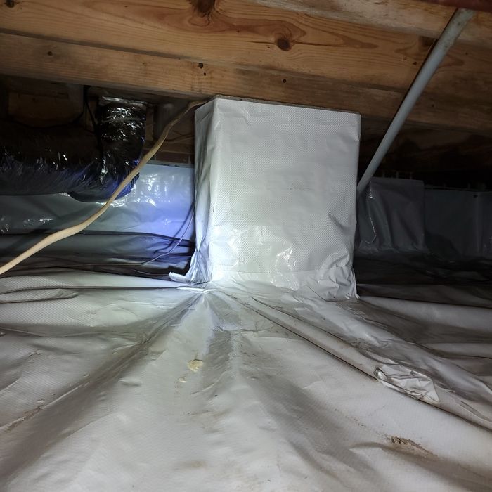 Crawl space with white plastic covering, insulation around a support beam, and ductwork.