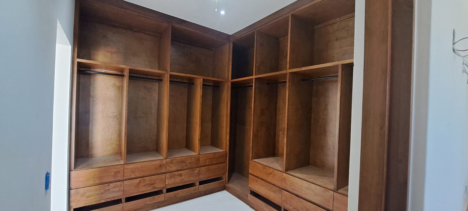 Un vestidor con muchos estantes y cajones de madera.