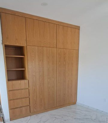 Un gran armario de madera con estantes y cajones en una habitación.