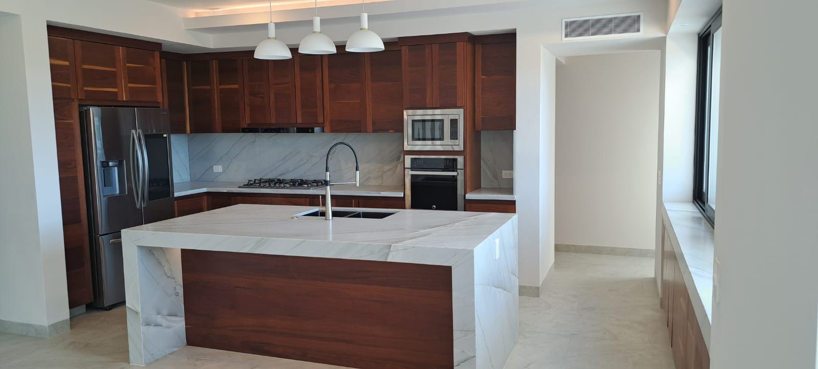 Una cocina con una gran isla en medio de la estancia.