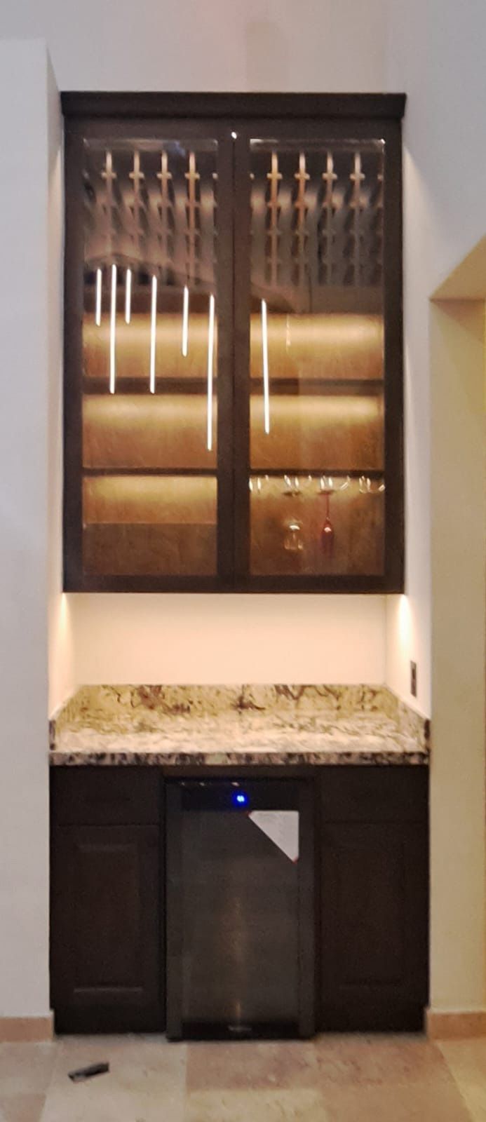 Una cocina con una vinoteca y una vitrina.