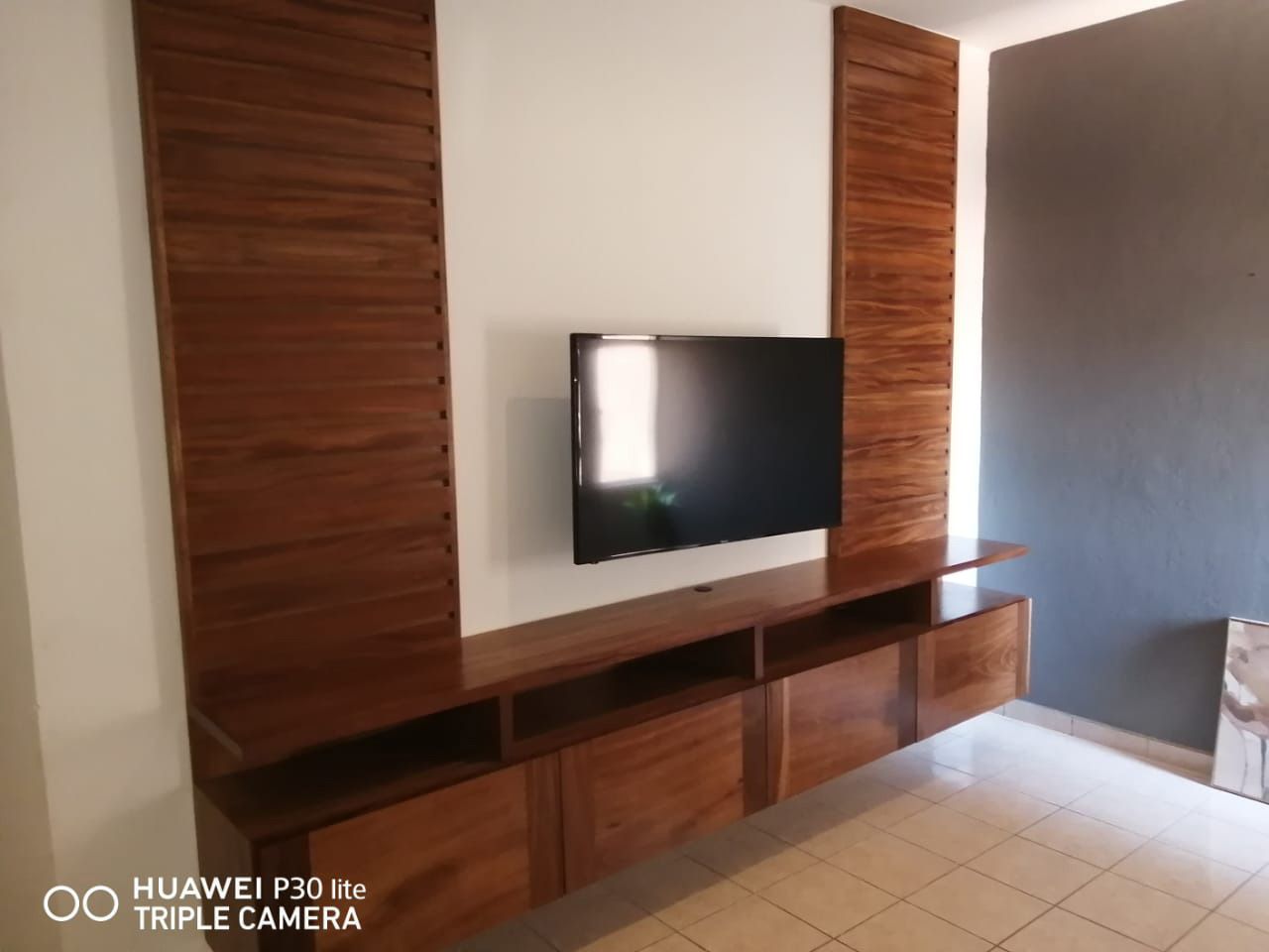 Una sala de estar con TV de pantalla plana montada en la pared.