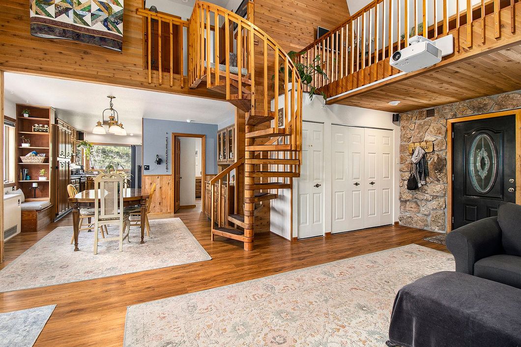 A living room with a spiral staircase leading to the second floor.