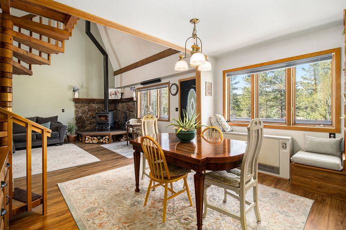 A dining room table and chairs in a house with a spiral staircase.