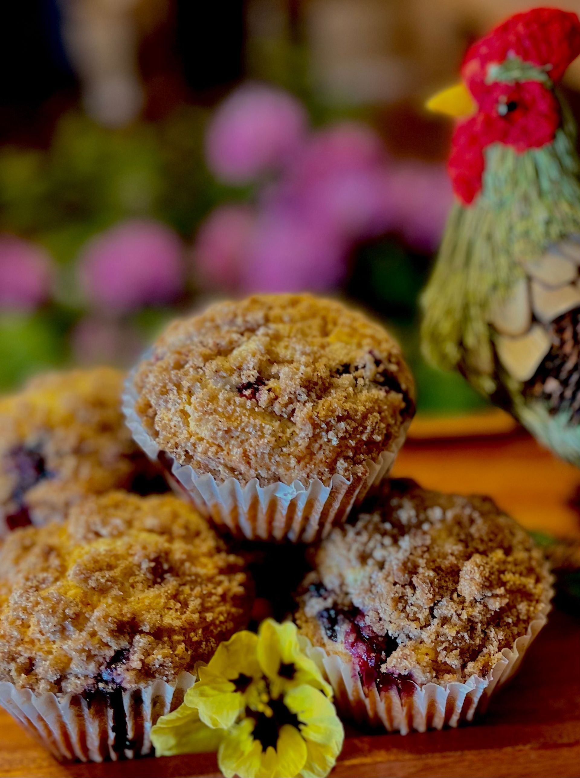 Stack of blueberry muffins with crumb topping, on a wooden surface, 