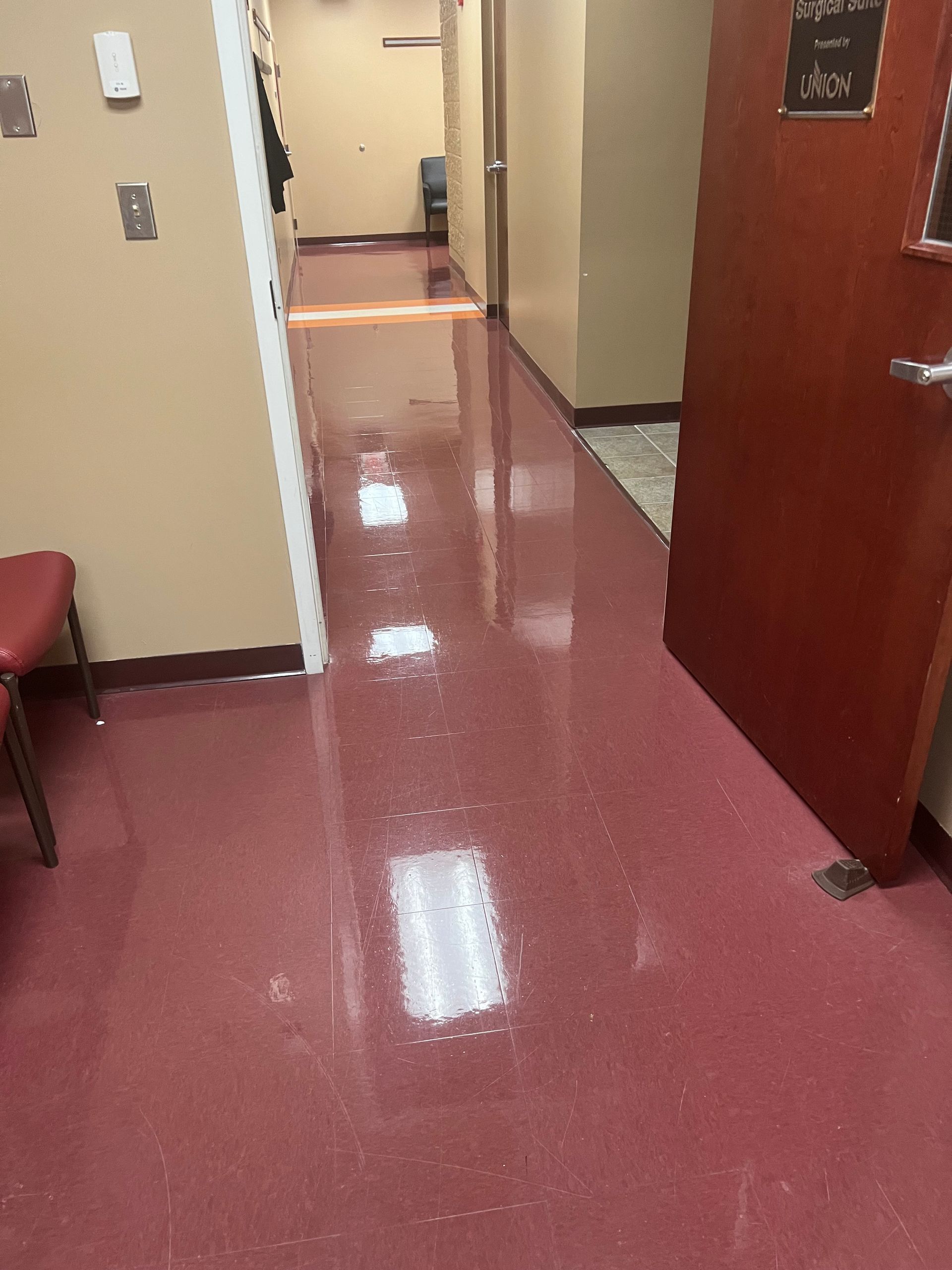 A hallway with a red floor and a red door