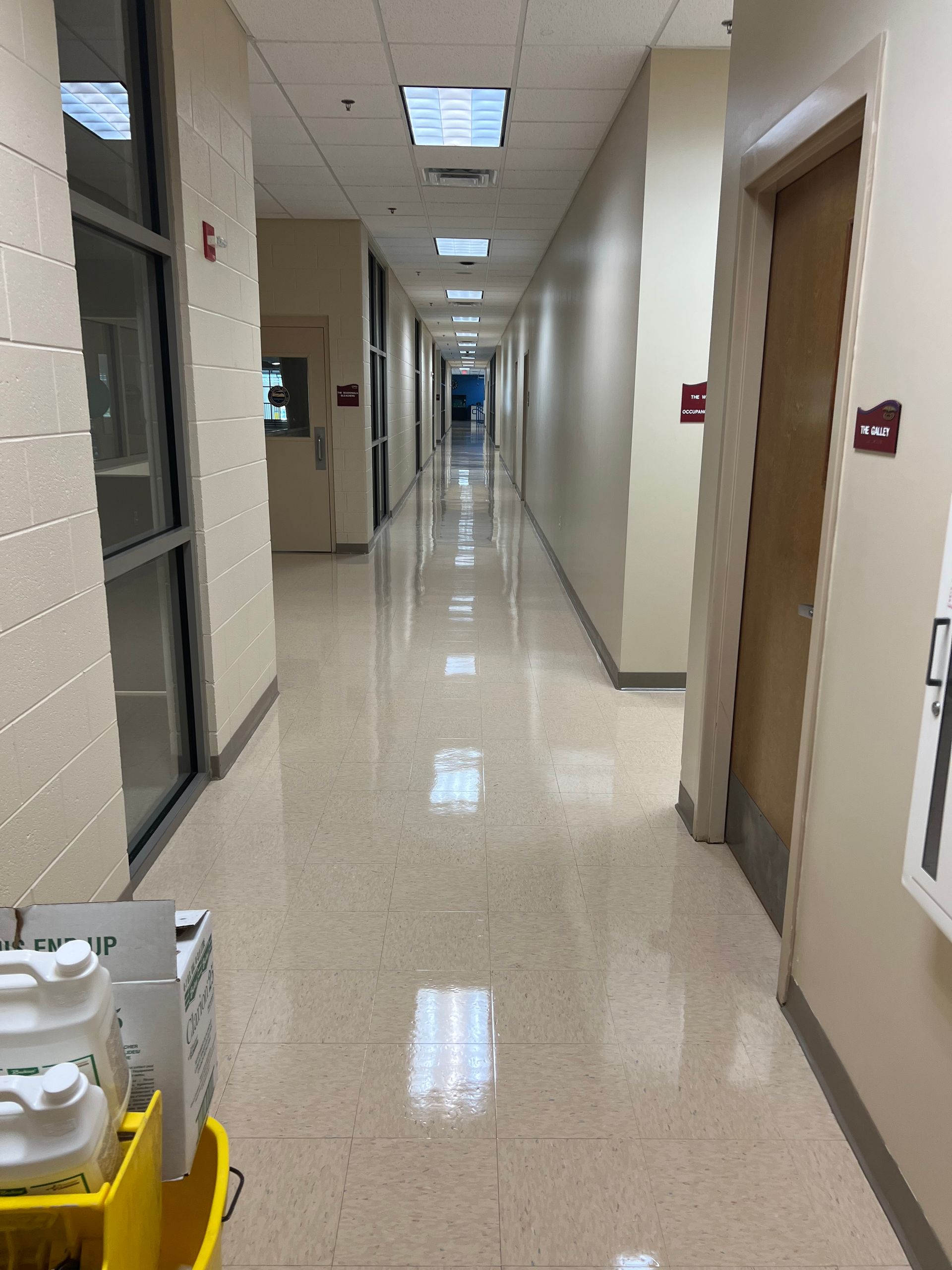 A long hallway with many doors and a shiny floor.
