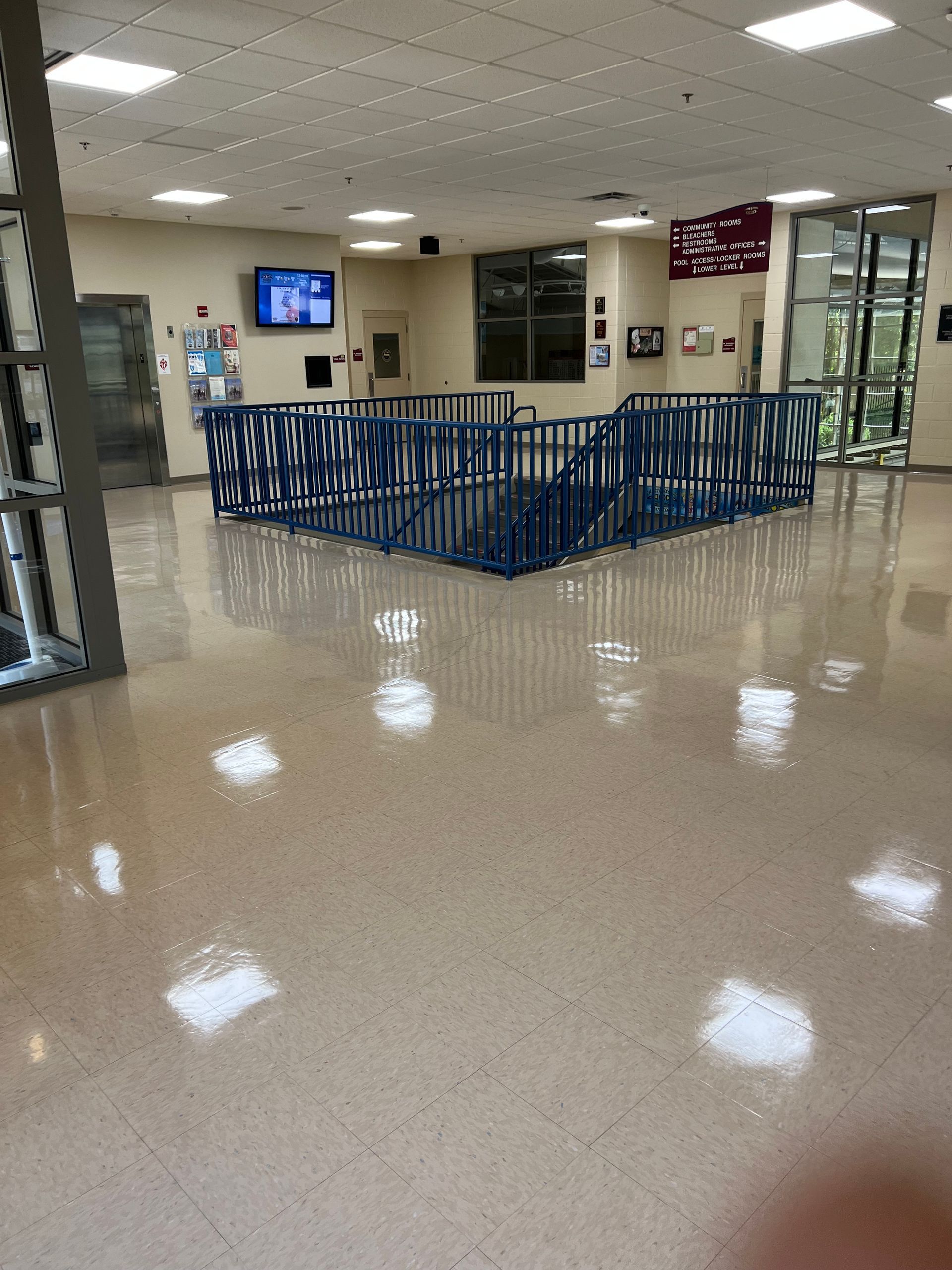 A large room with a blue fence and a tv on the wall.