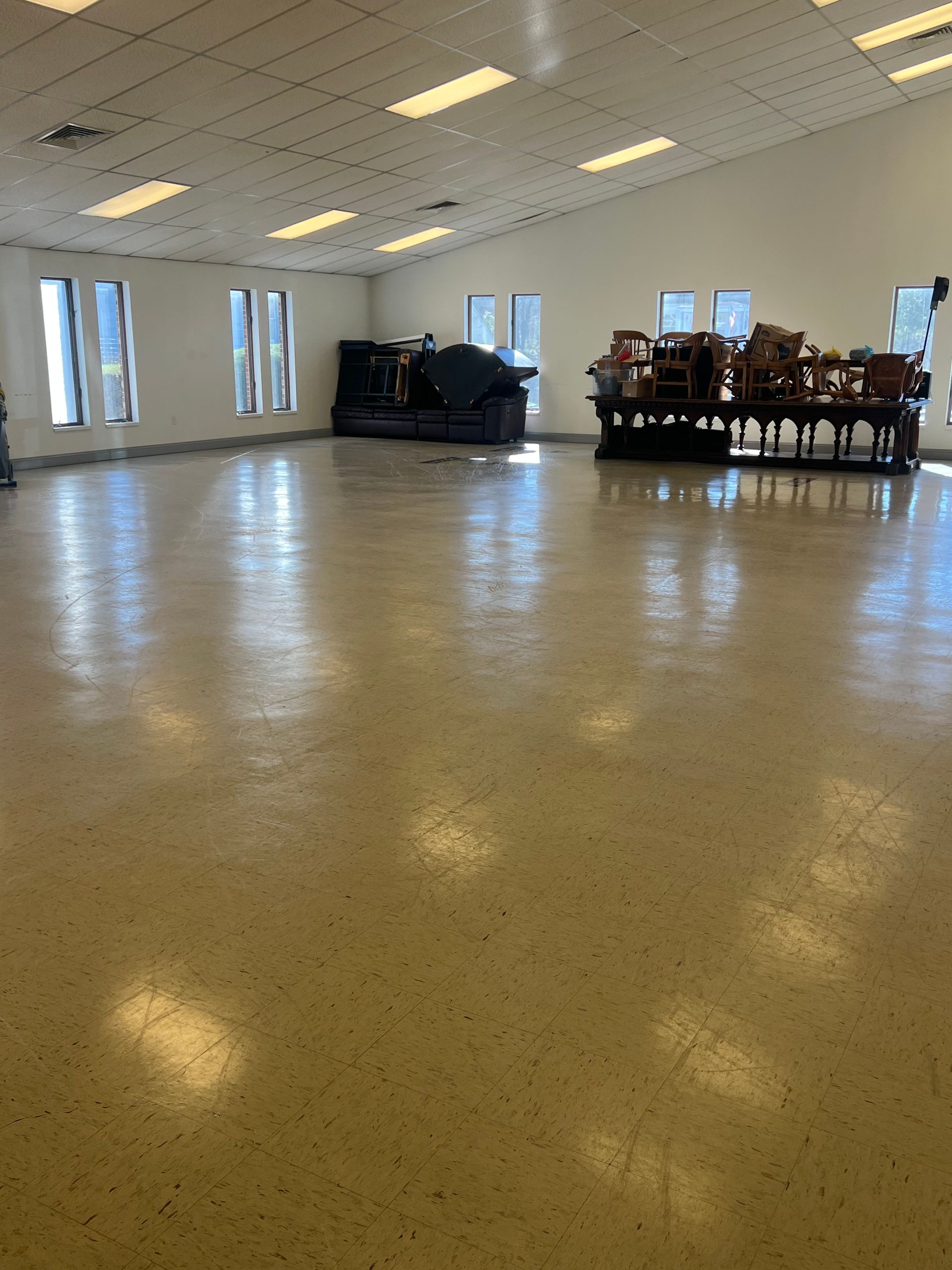 A large room with a couch and chairs in it.