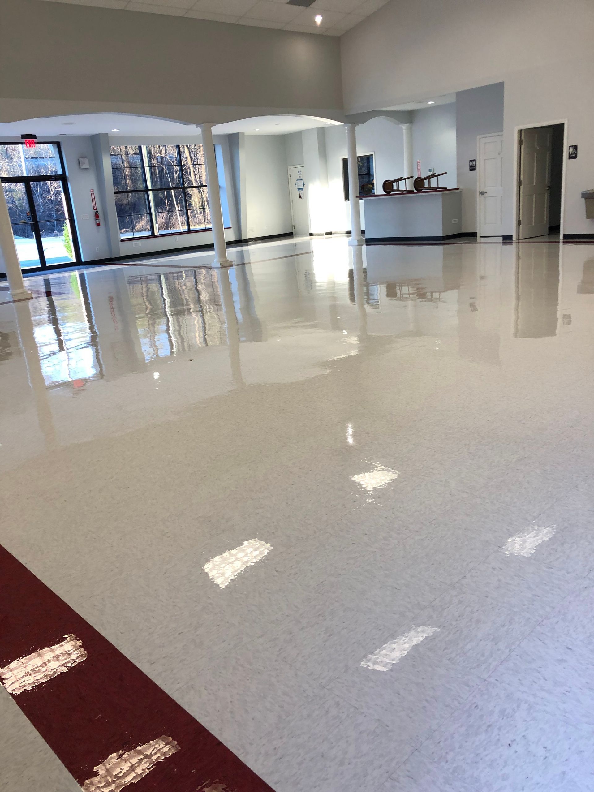 A large room with a lot of windows and a shiny floor