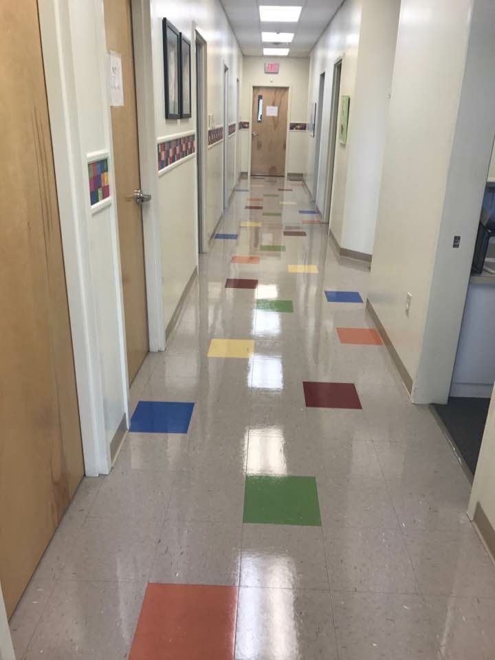 A long hallway with colorful tiles on the floor.