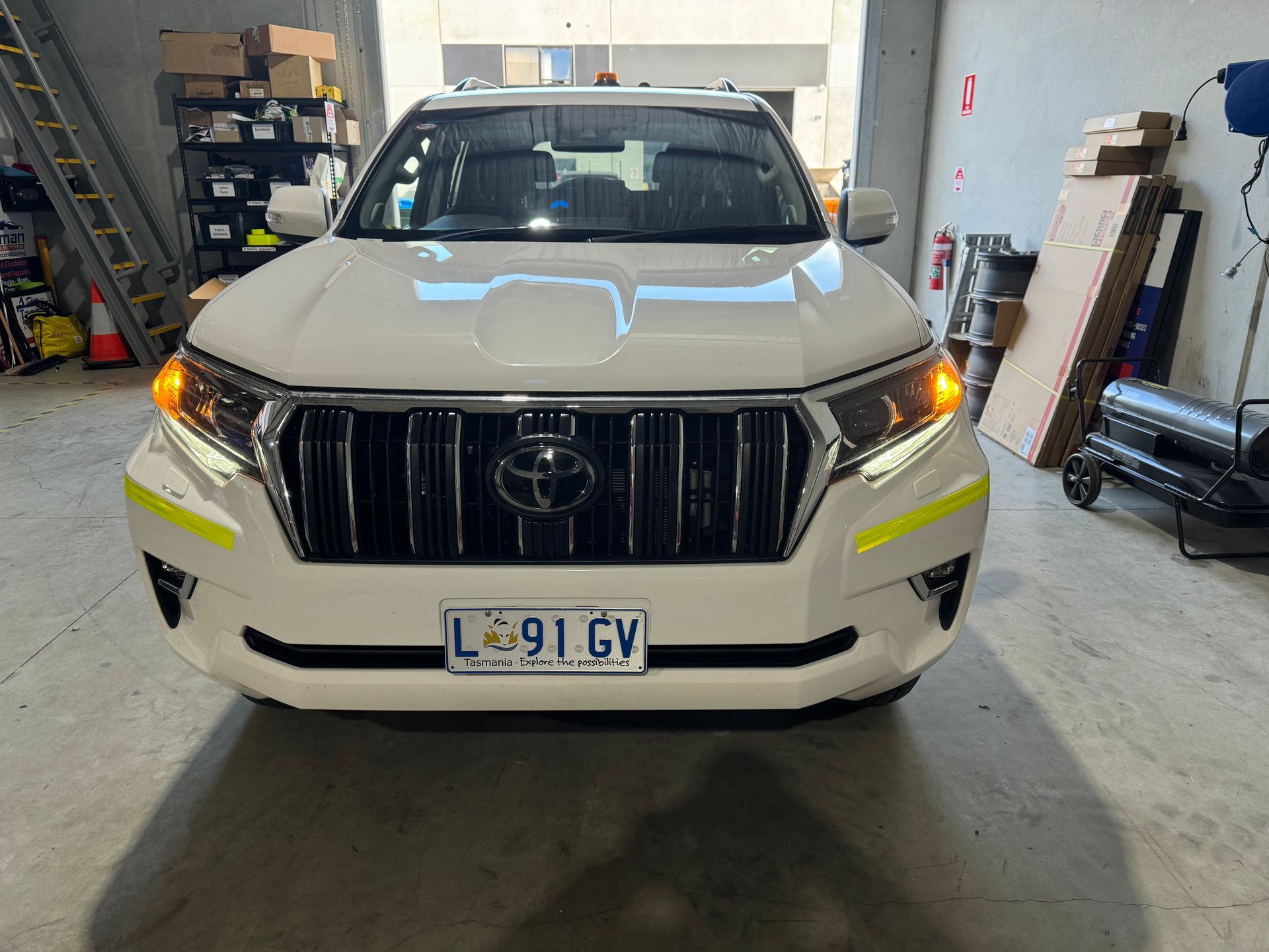 White Toyota SUV with emergency vehicle markings in a garage.