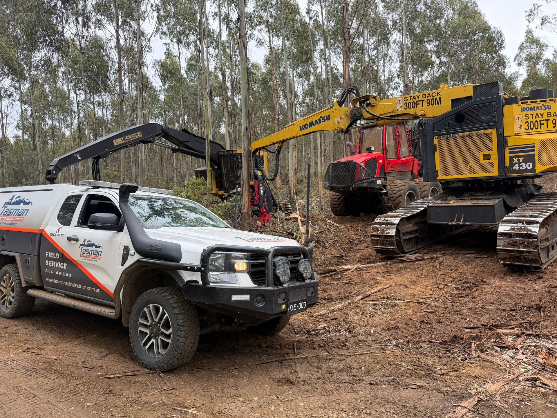 A mobile auto electrician checking the voltage on a car battery.