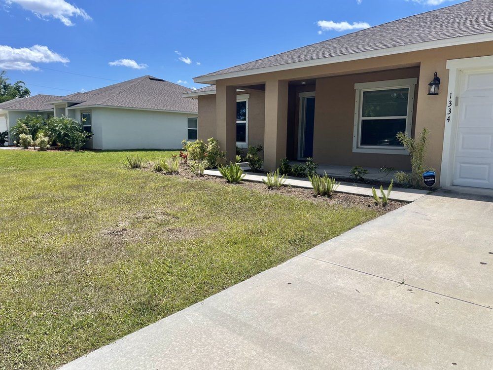 The front of a house with a concrete walkway leading to it.