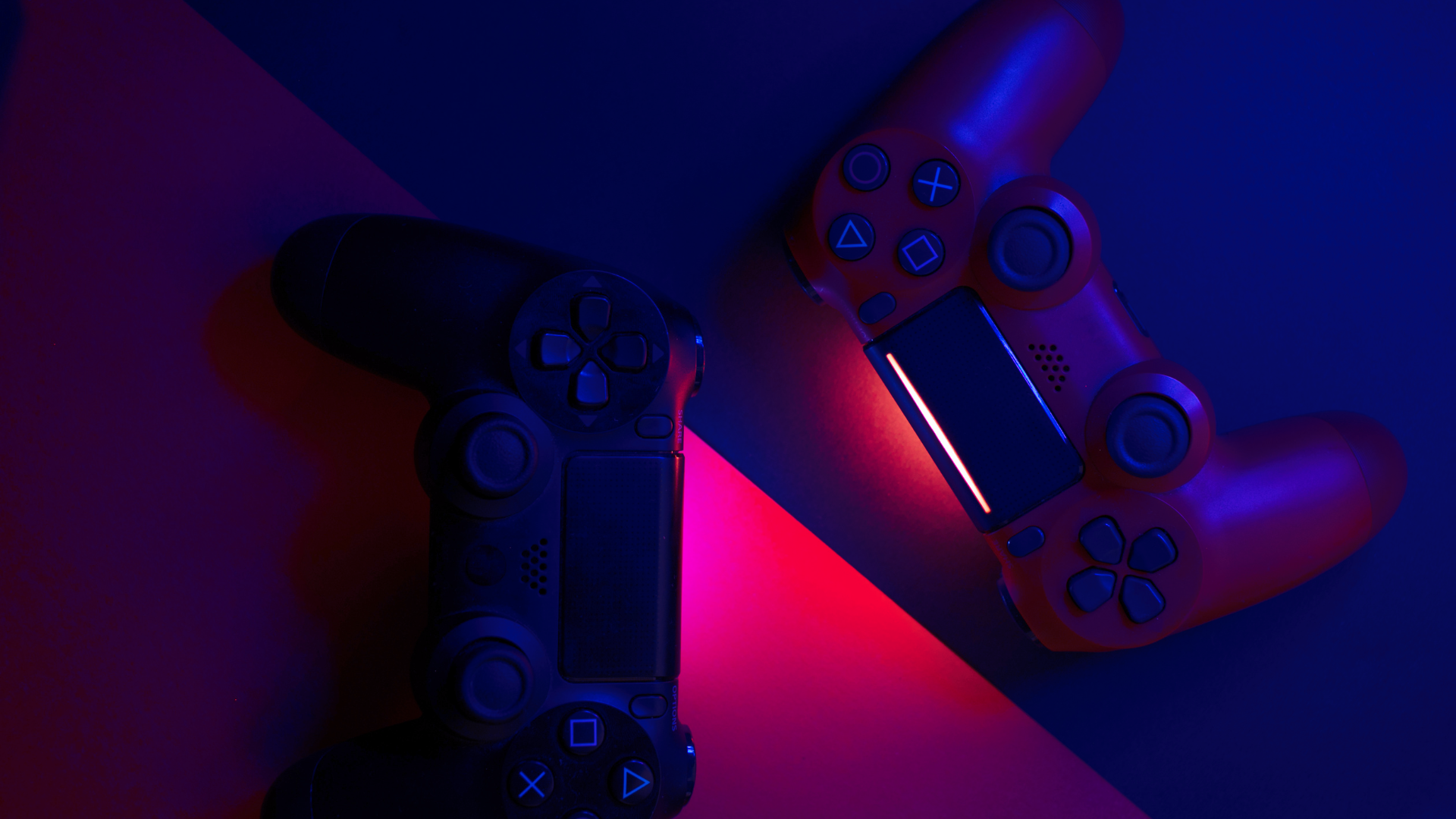 Two video game controllers are sitting next to each other on a table.