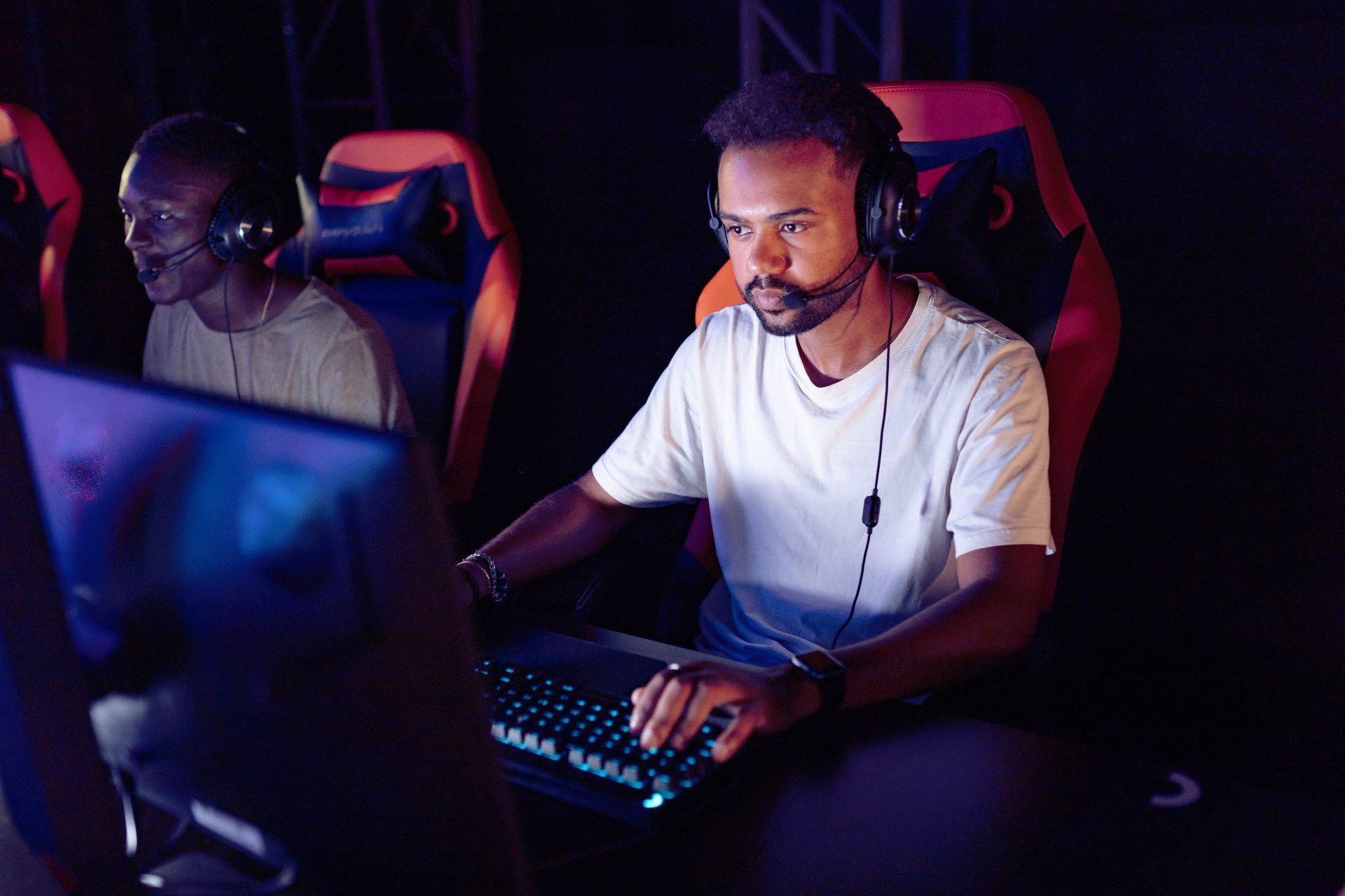 A man wearing headphones is playing a video game on a computer.