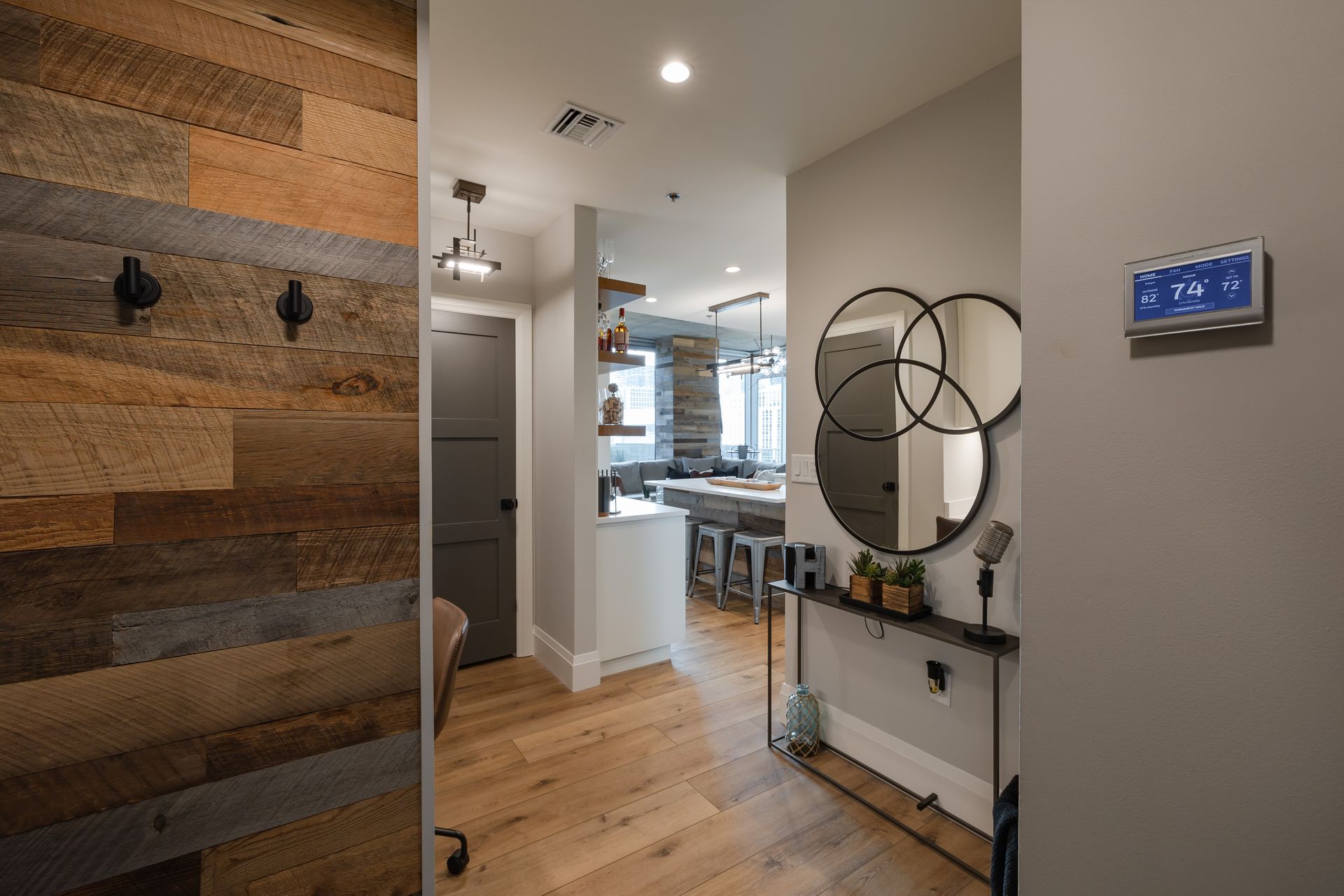 A hallway in a house with a wooden wall and a mirror.