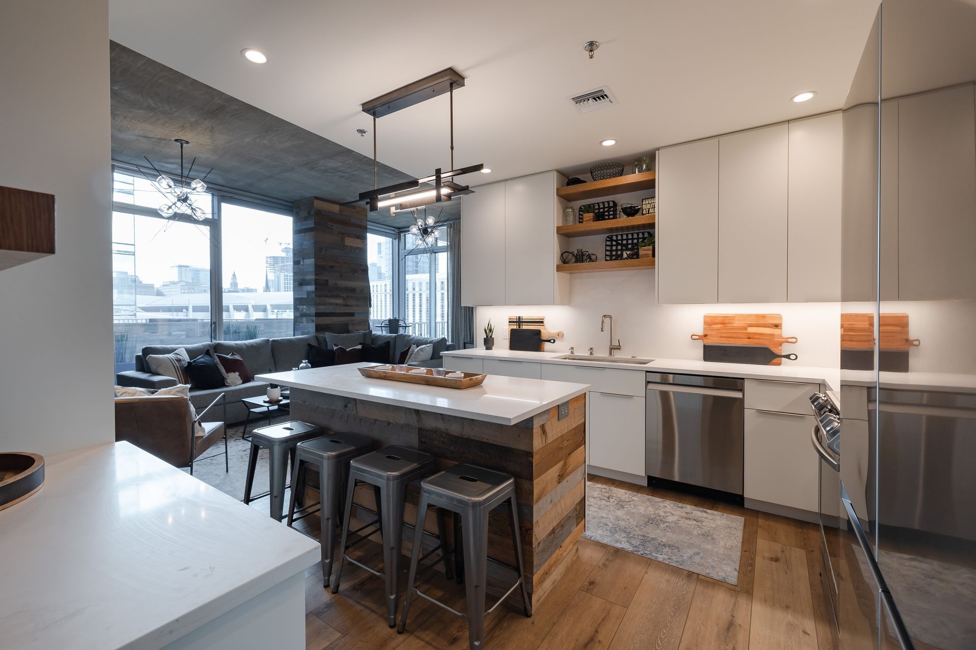 A kitchen with white cabinets and stainless steel appliances and a large island in the middle.