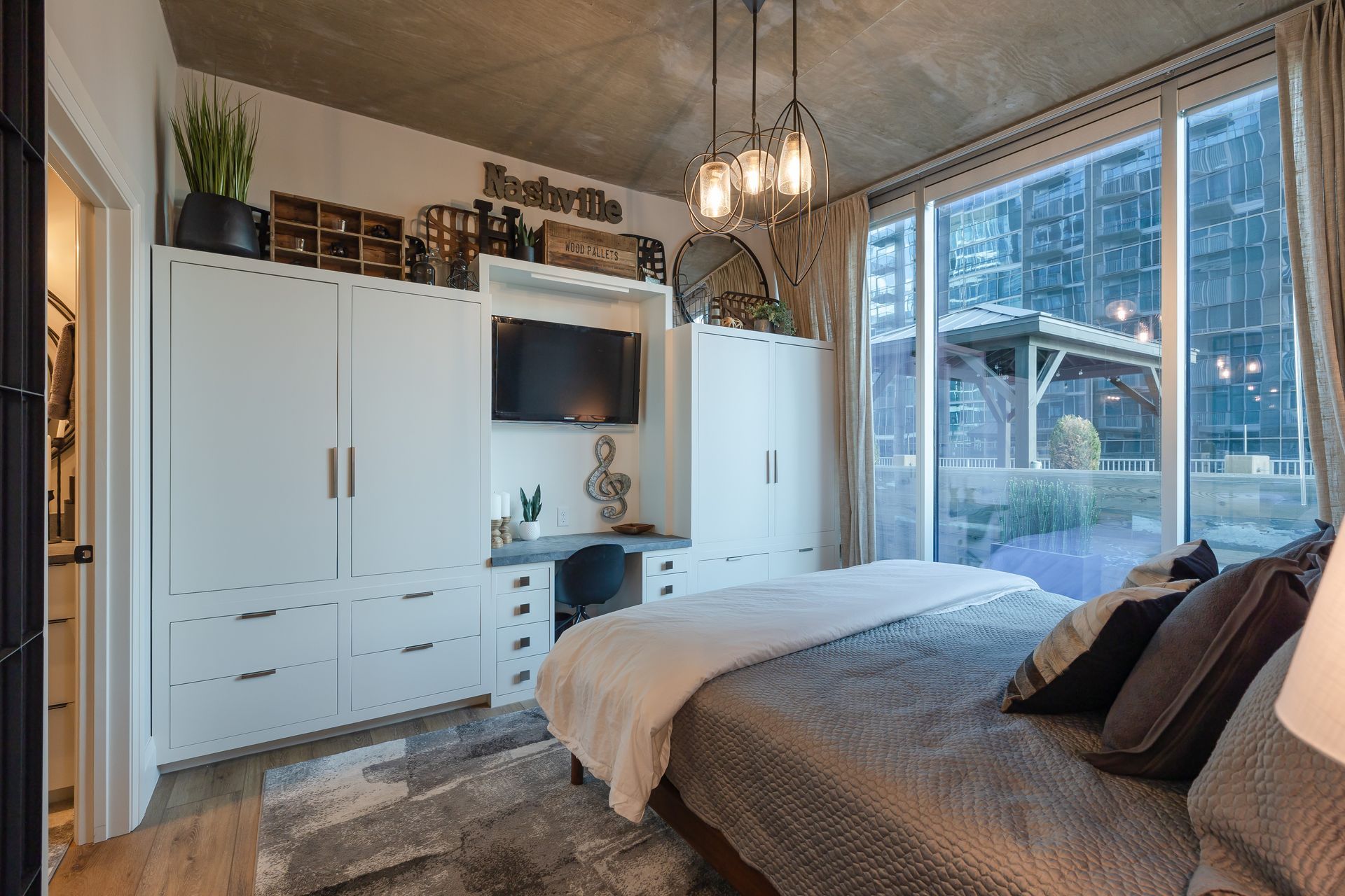 There is a large bed in the middle of the room with a large window.