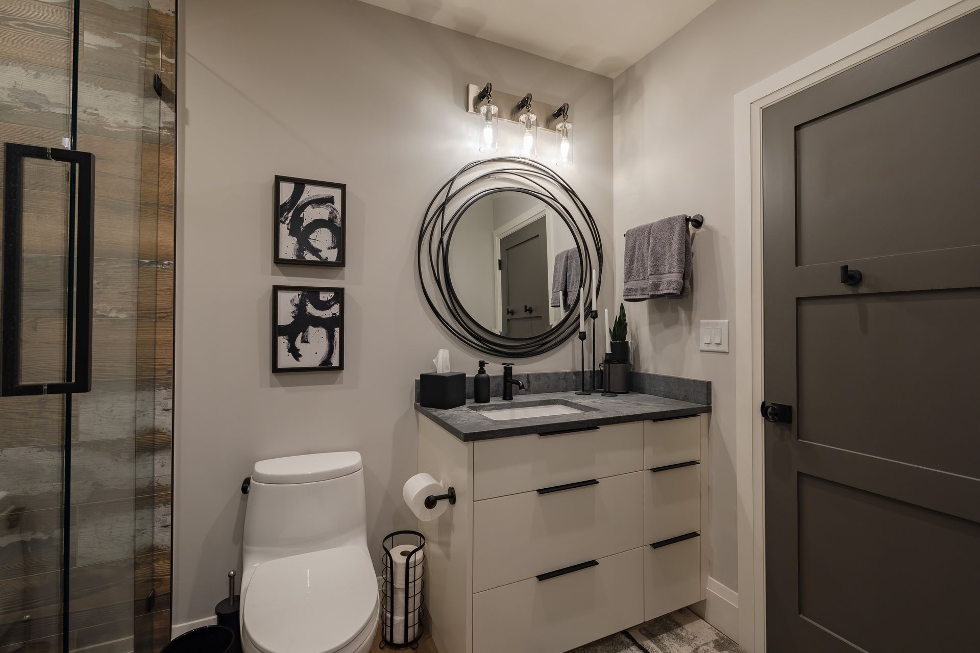 A bathroom with a toilet , sink , mirror and shower.