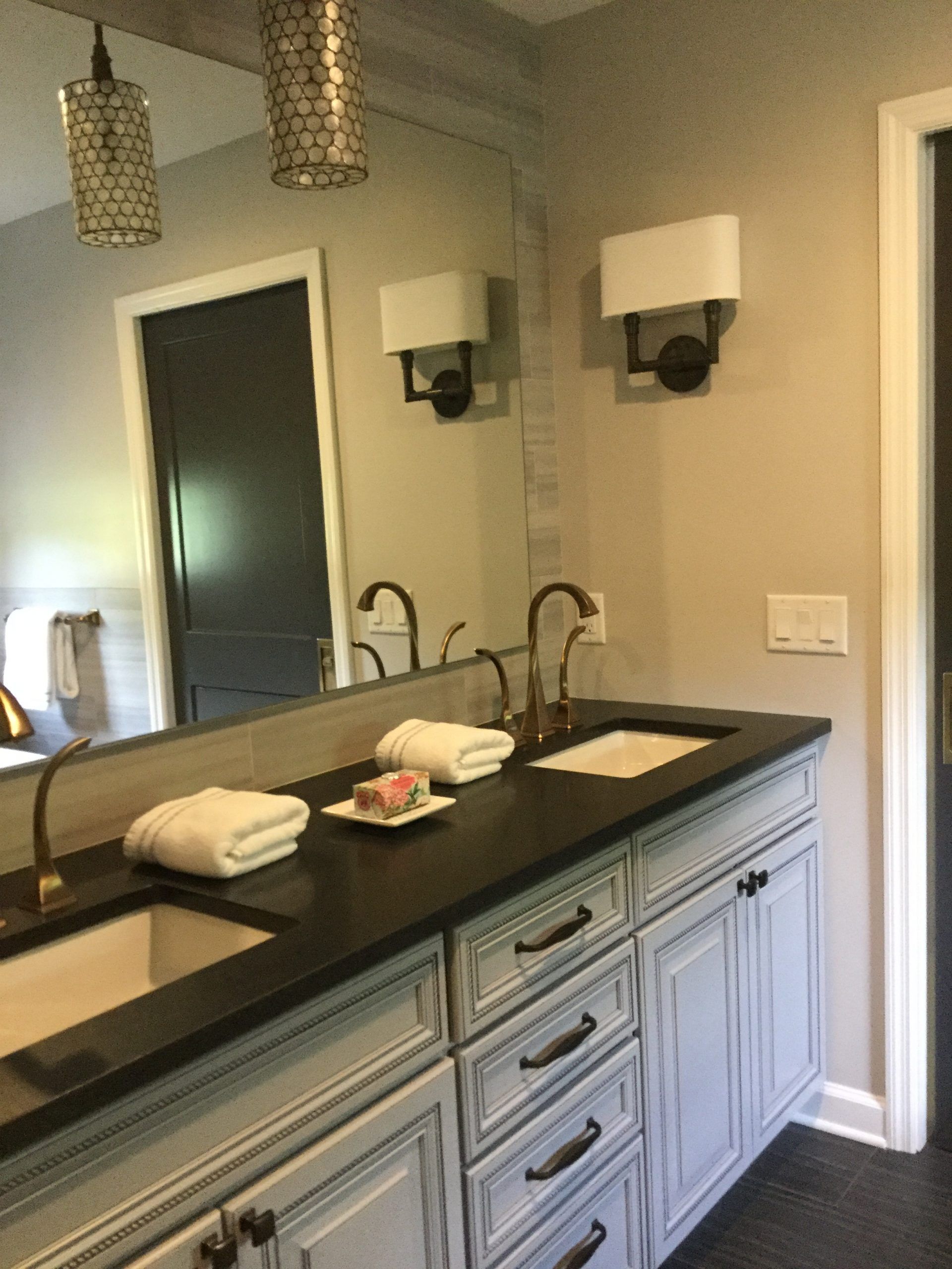 A bathroom with two sinks and a large mirror