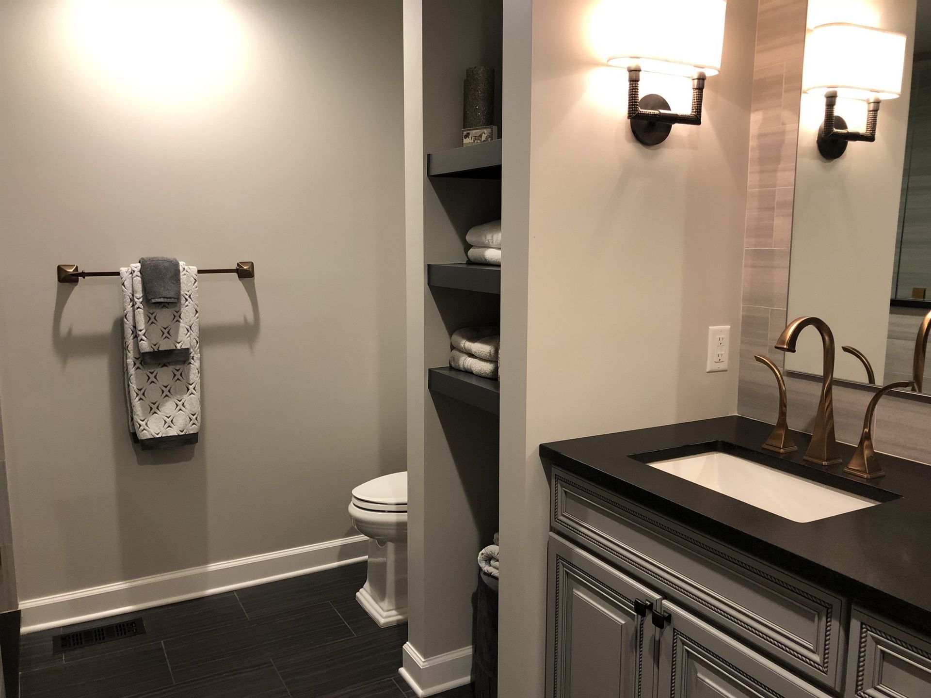 A bathroom with a sink , toilet and mirror.