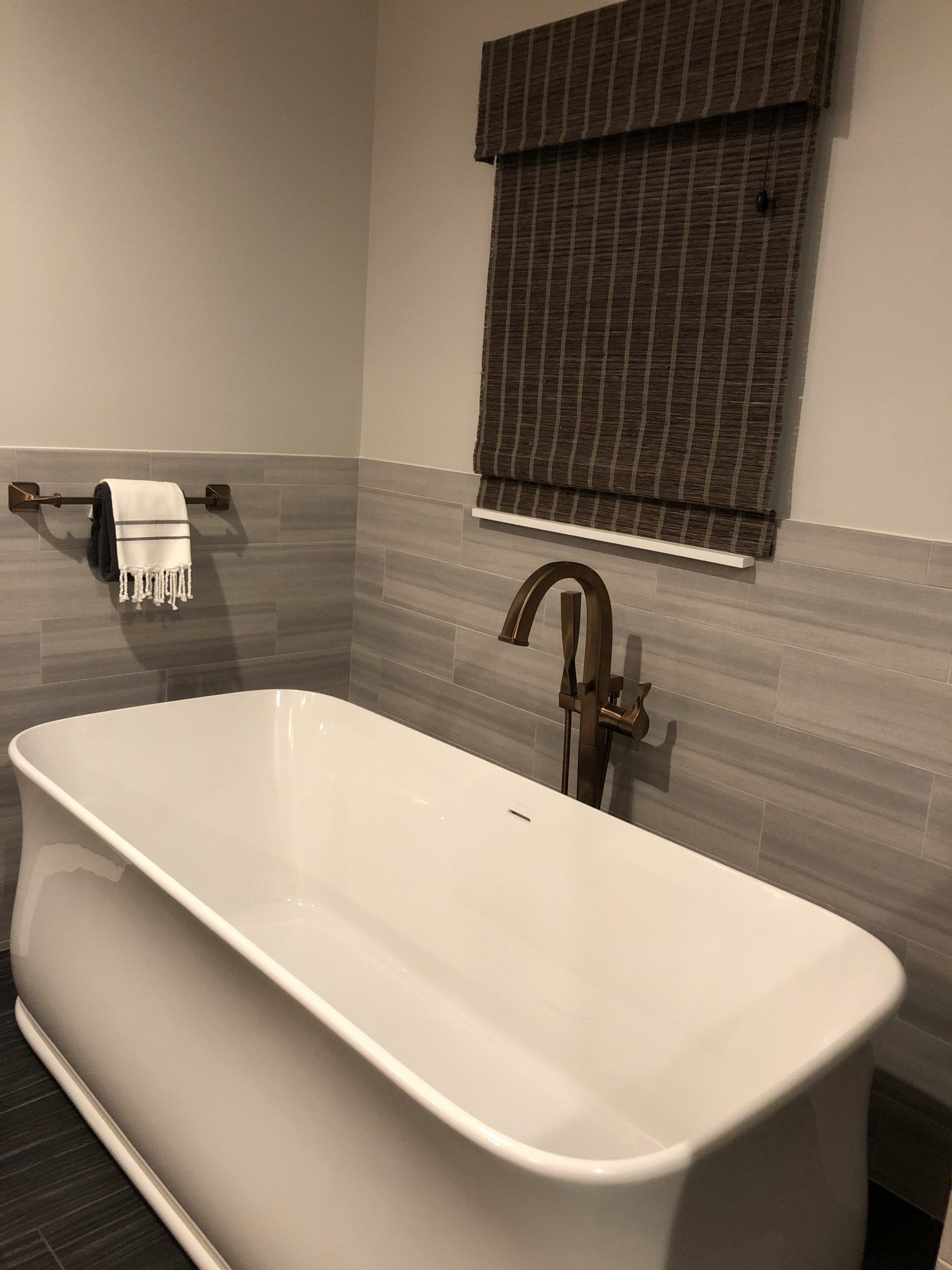 A bathtub is sitting in a bathroom next to a window.