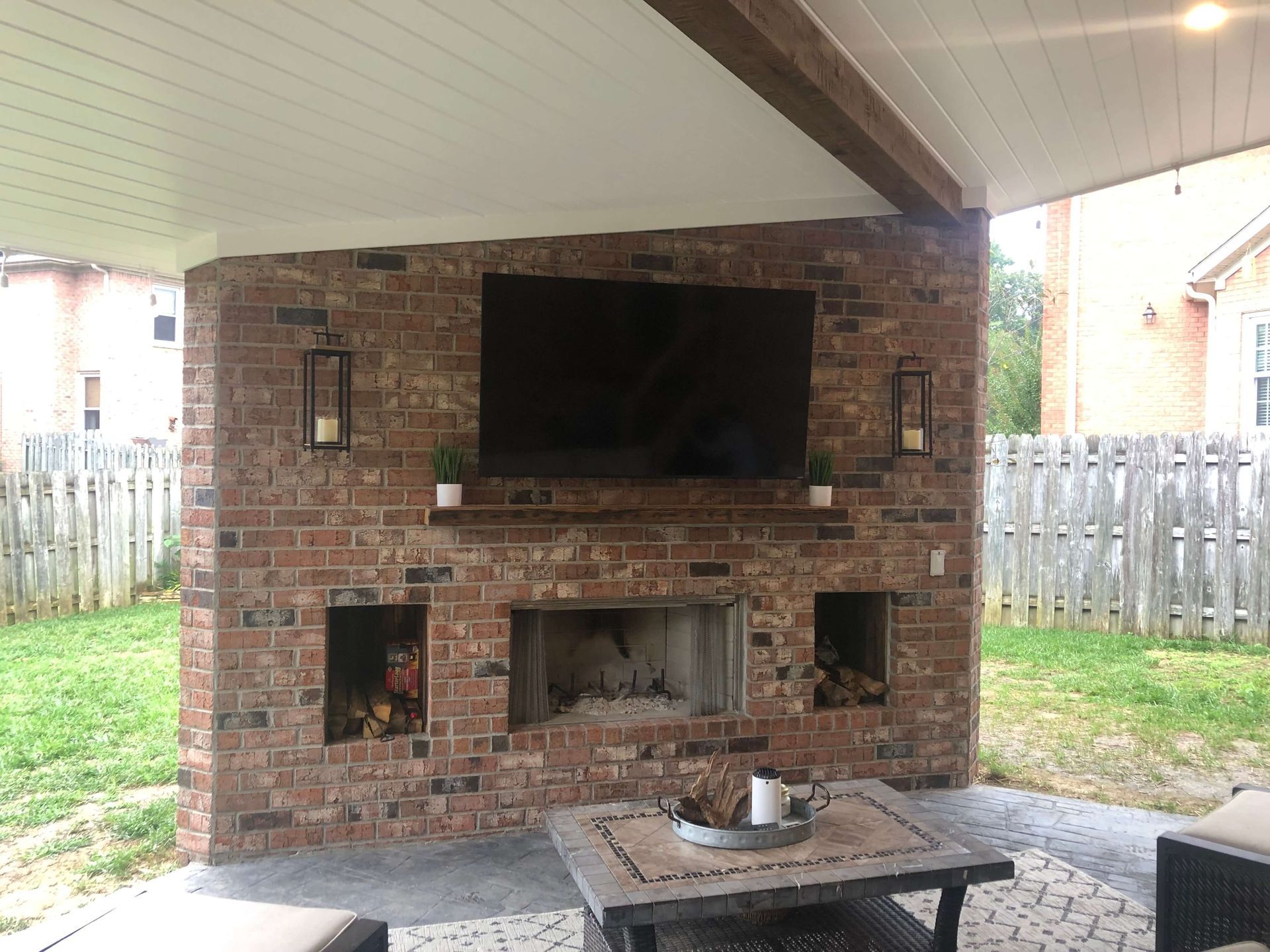 A brick fireplace with a flat screen tv mounted above it.