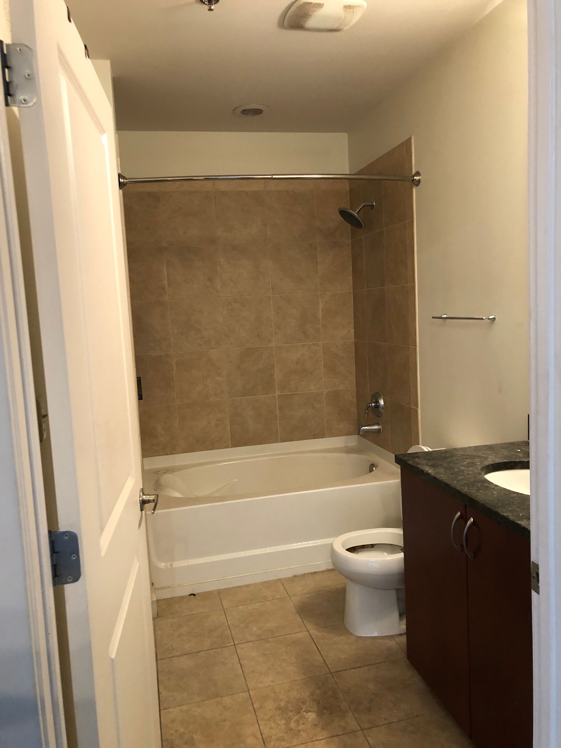 A bathroom with a tub , toilet , sink and shower.
