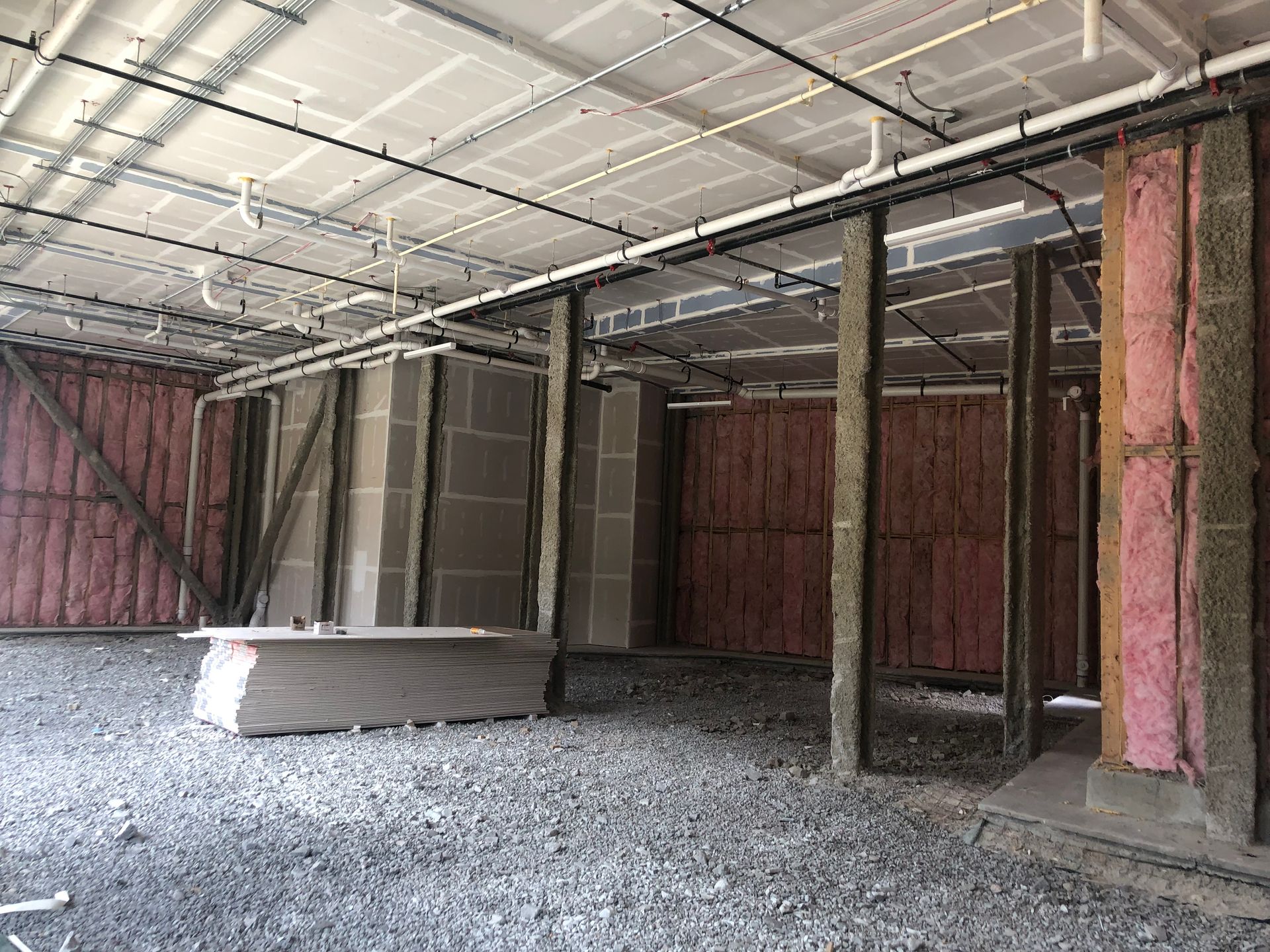 A very large room with a lot of pipes hanging from the ceiling.