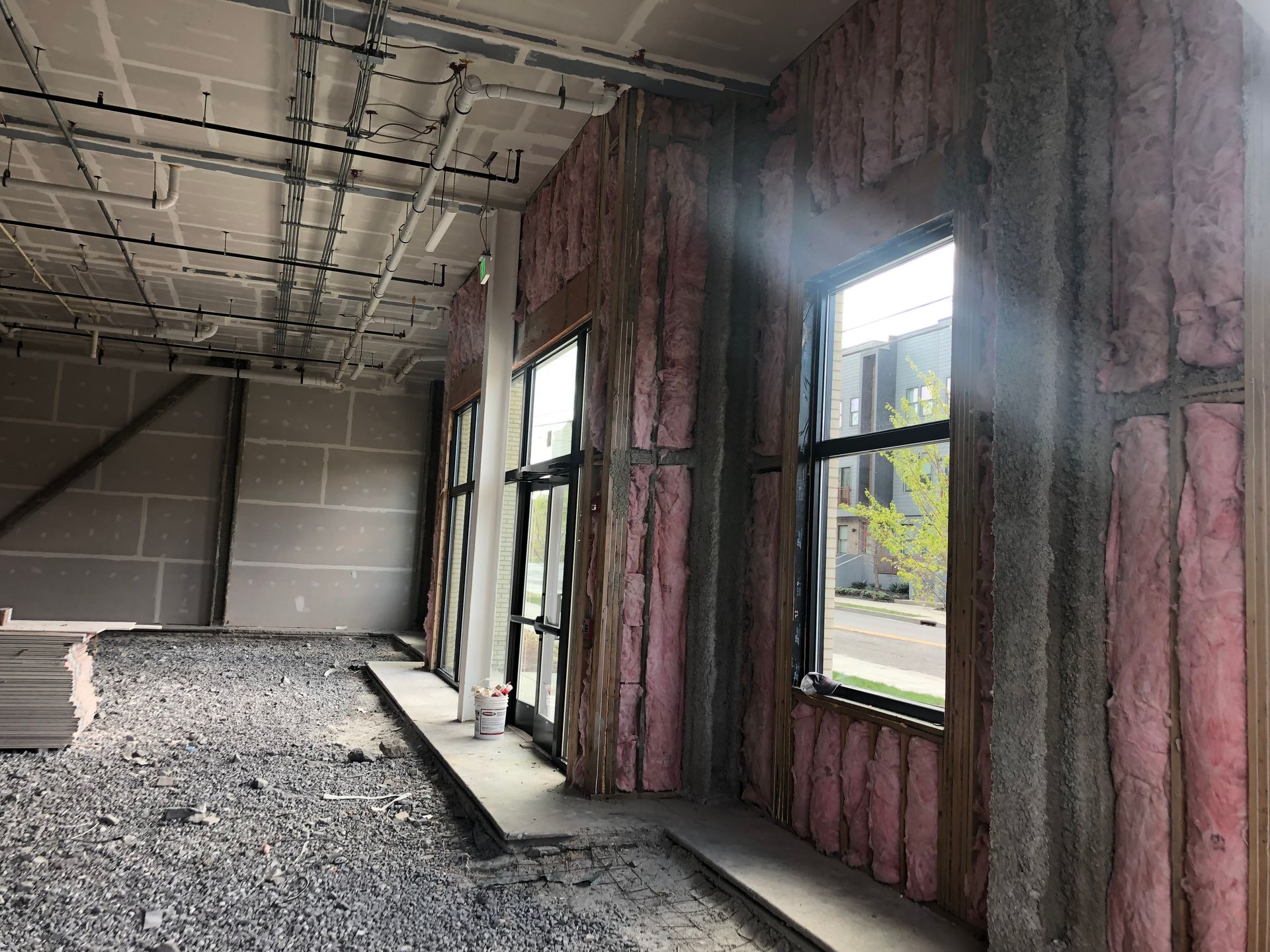A room with a lot of windows and pink insulation on the walls.