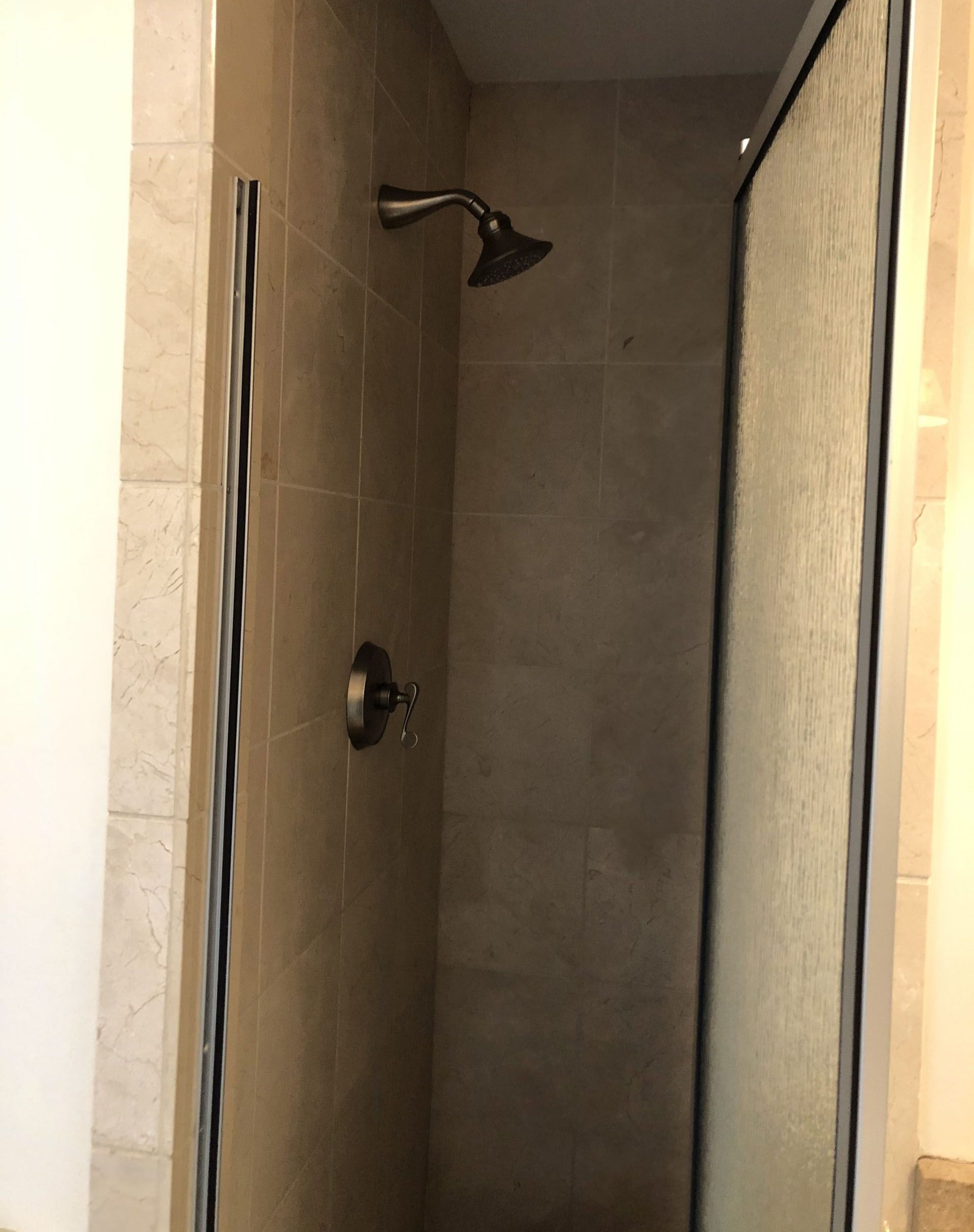 A shower with a shower head and a glass door.