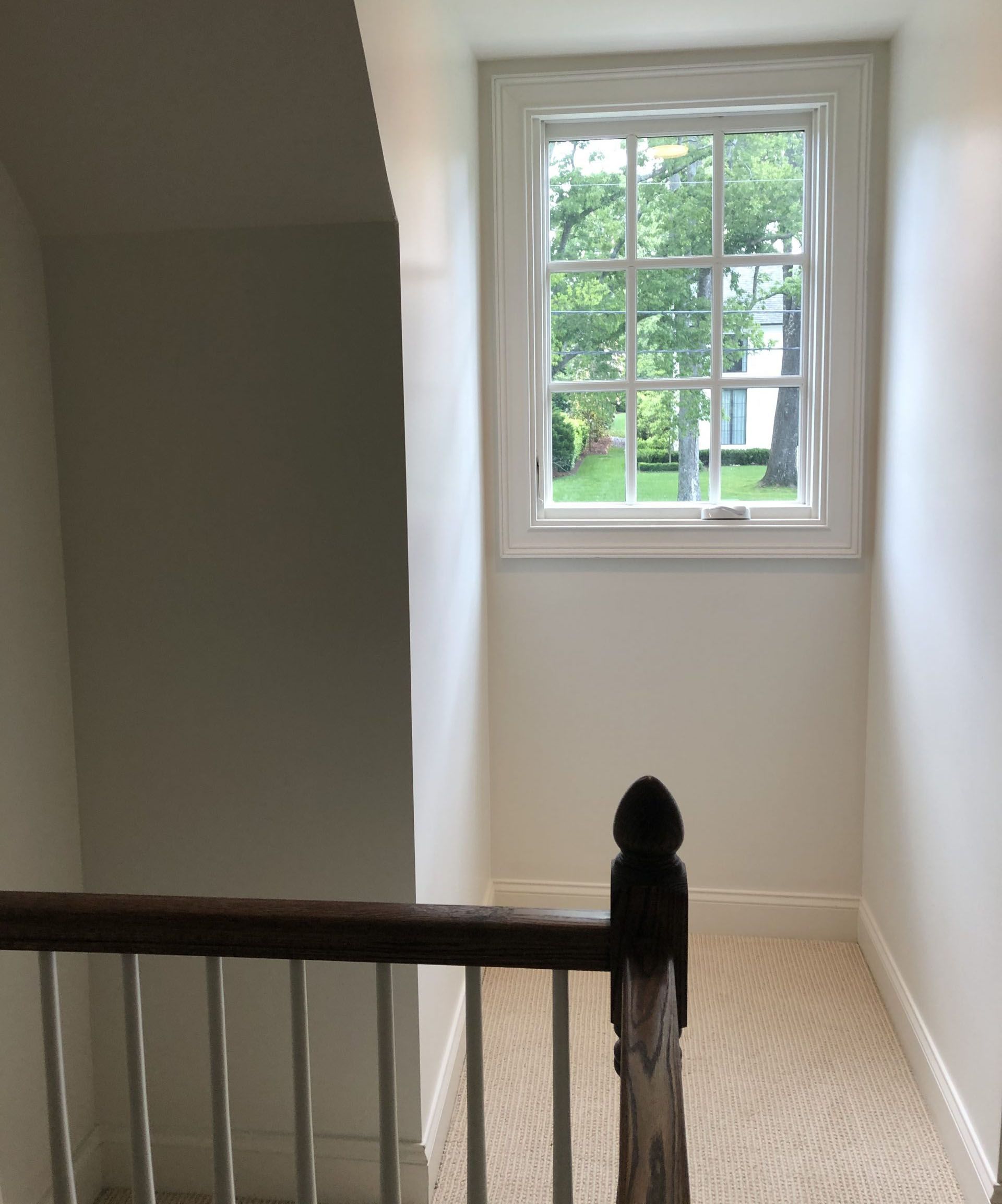 A staircase with a wooden railing and a window