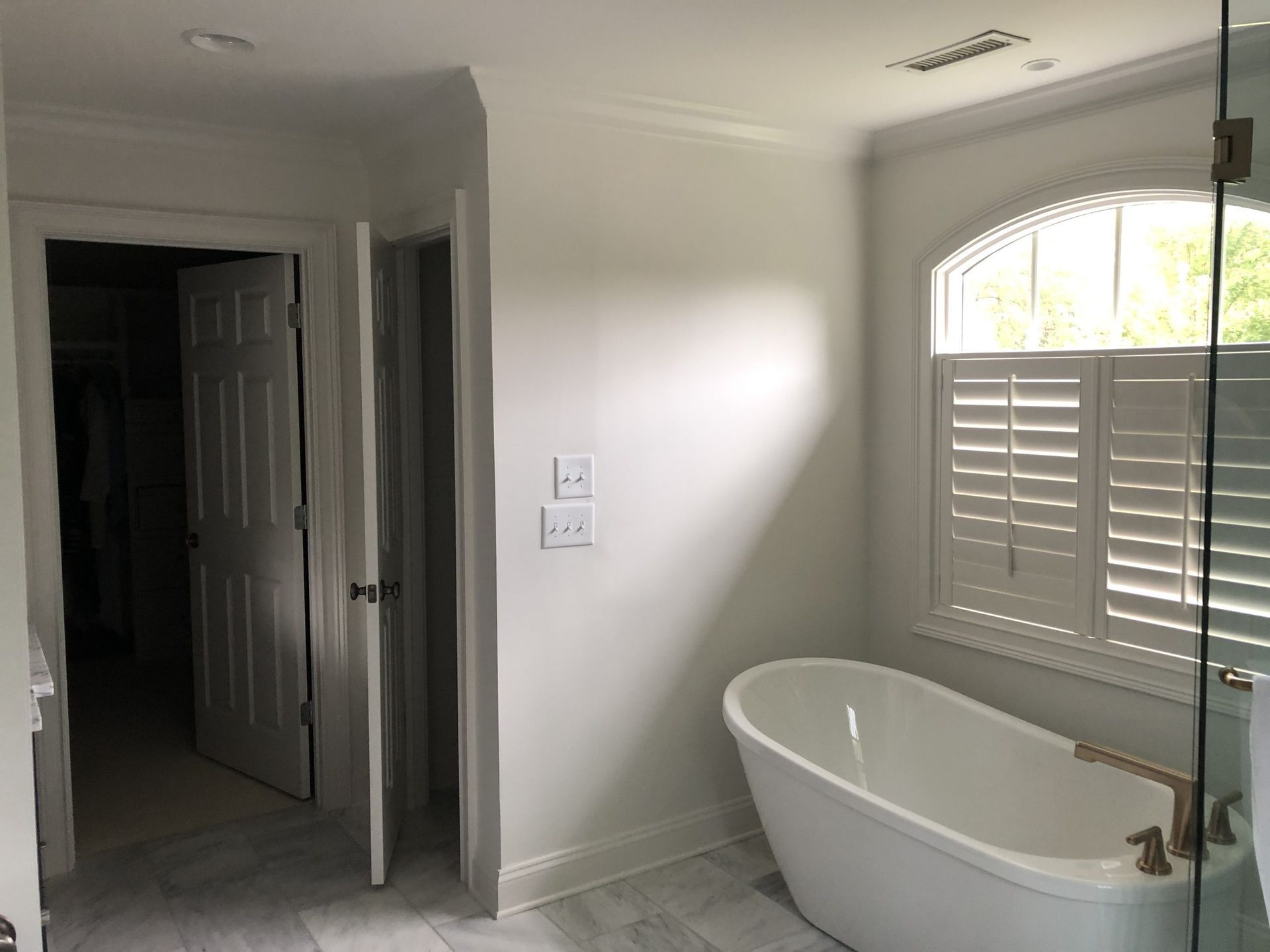 A bathroom with a tub and a window.